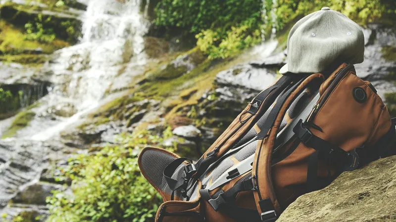 A backpack resting on top of a boulder