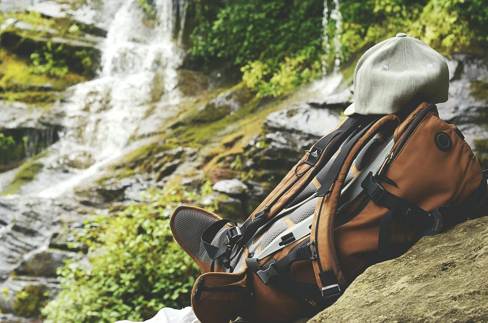 A backpack resting on top of a boulder