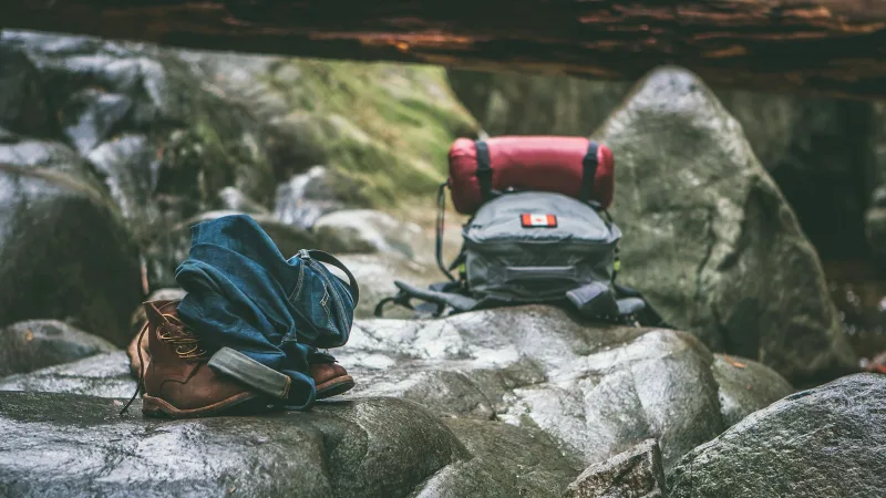 Two gray and orange backpacks on gray rocks